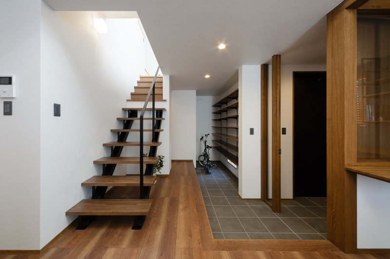 玄関から繋がるテラス土間空間には大容量の収納を確保。ストリップ階段で空間に広がりを持たせる